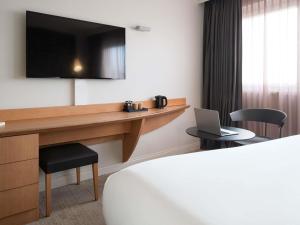 a hotel room with a desk with a laptop on it at Mercure Paris La Défense in Courbevoie +116 photos