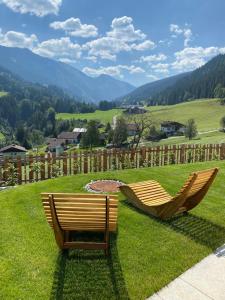 two chairs sitting on a lawn with mountains in the background at Apartment 225 in Forstau