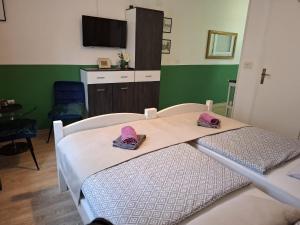 a hospital room with a bed with pink slippers on it at Rooms Bobic in Ličko Petrovo Selo