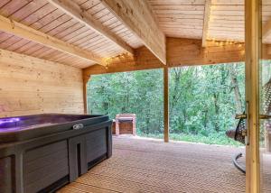 a large screened porch with a large tub in a wooden house at Quarry Walk Lodges in Cheadle