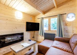 a living room with a couch and a flat screen tv at Quarry Walk Lodges in Cheadle