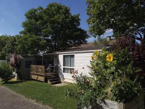 a small white cottage with a porch and a yard at Camping Beausejour Sergines in Sergines +11 photos
