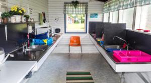 a kitchen with two sinks and a orange stool at Norbergs Camping in Norberg