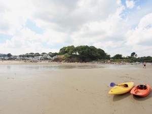Zwei Kajaks an einem Strand, im Hintergrund Menschen. in der Unterkunft Flat 2 - Uk49045 in Narberth
