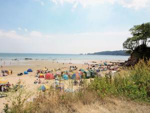 Eine Menschenmenge mit Sonnenschirmen an einem Strand in der Unterkunft Flat 2 - Uk49045 in Narberth