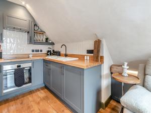 eine Küche mit blauen Schränken und einer Arbeitsplatte in der Unterkunft Flat 2 - Uk49045 in Narberth