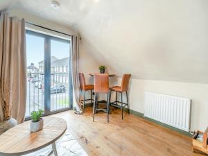 ein Wohnzimmer mit Tisch und Stühlen und einem Fenster in der Unterkunft Flat 2 - Uk49045 in Narberth