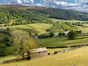 an old stone building in a green field at Rosemount Cottage in Salterforth