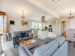 a living room with two blue couches and a kitchen at Park View - Uk46898 in Kinlet +5 photos