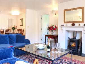 a living room with a blue couch and a fireplace at Stokewood Annexe in Freshford