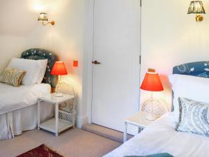 a room with two beds and two lamps on tables at Stokewood Annexe in Freshford