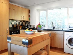 a kitchen with a bowl of fruit on a wooden island at Stokewood Annexe in Freshford +6 photos