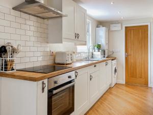 a kitchen with white cabinets and a counter top at Y Gorlan - Uk6403 in Llanllechid