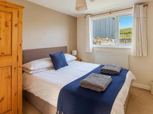 a bedroom with a bed with two towels on it at Y Gorlan - Uk6403 in Llanllechid