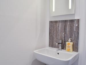 a white bathroom with a sink and a mirror at Penmaen in Talgarth