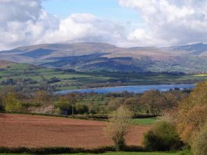 a view of a valley with a lake and mountains at Penmaen in Talgarth