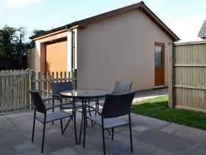 a patio with a table and chairs and a fence at Penmaen in Talgarth