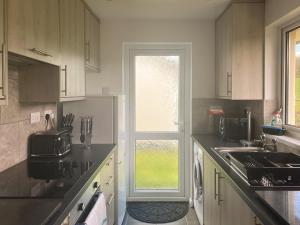 a kitchen with a refrigerator and a sink and a window at Eden - B6526 in Saint Cleer