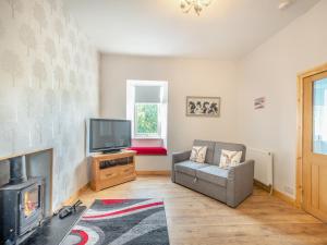 a living room with a fireplace and a tv at Lincumtoy in Pinwherry