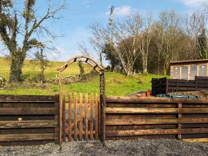 a wooden fence with an arch in a field at Lincumtoy in Pinwherry +6 photos