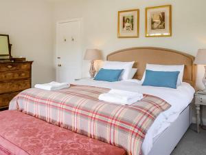 a bedroom with two beds with blue pillows at Glanusk Lodge - Uk46654 in Crickhowell