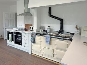 a kitchen with a stove and a stove top oven at Glanusk Lodge - Uk46654 in Crickhowell