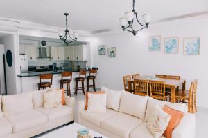 a living room with a white couch and a kitchen at 3 Min Walk to Bibijagua Beach - Spacious 2BR in Punta Cana