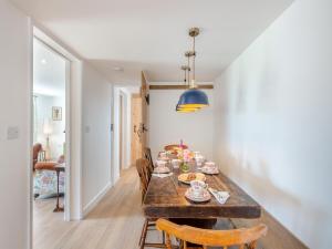 a dining room with a wooden table and chairs at Manor Cottage in Longham