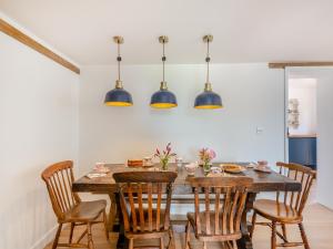 a dining room with a wooden table and chairs at Manor Cottage in Longham