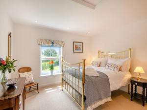 a bedroom with a bed and a window at Manor Cottage in Longham +16 photos