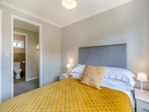 a bedroom with a large bed with a yellow blanket at Winnal View - Uk46891 in Kinlet +7 photos