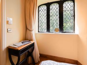 a bedroom with a window and a table with a book at The Tower - Uk46652 in Crickhowell +8 photos