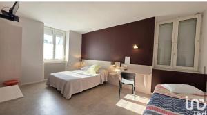 a bedroom with a bed and a desk and a sink at Au bon saint Nicolas in Hillion