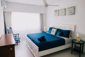 a bedroom with a bed with blue sheets and a teddy bear on it at 3 Min Walk to Bibijagua Beach - Spacious 2BR in Punta Cana +61 photos