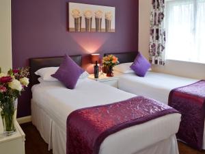 two beds in a room with purple walls at Trebah - B5623 in Saint Cleer
