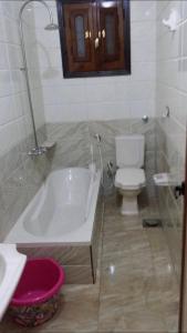 a bathroom with a white tub and a toilet at Sharqeh apartment in Sintrīs