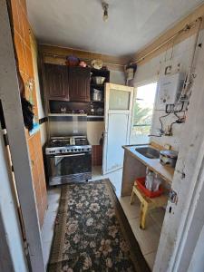 a small kitchen with a stove and a sink at Sharqeh apartment in Sintrīs