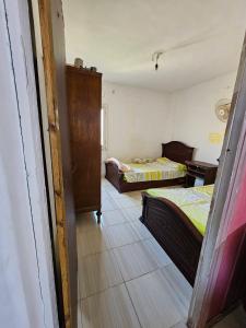 a room with two beds and a door to a bedroom at Sharqeh apartment in Sintrīs