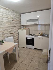 a kitchen with white cabinets and a sink and a stove at Apartments and Rooms Jasna in Hvar