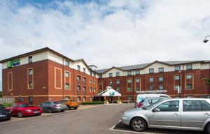 a parking lot with cars parked in front of a building at Holiday Inn Express Bristol Filton by IHG in Bristol