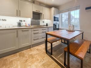 a kitchen with white cabinets and a wooden table at Dory in Rye