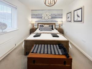 a bedroom with a bed with a chest at the end at Dory in Rye