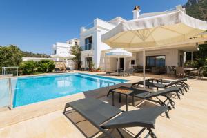 a villa with a swimming pool and patio furniture at Villa Yakamoz in Kalkan +25 photos