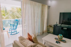 a living room with a couch and a sliding glass door at 3 Min Walk to Bibijagua Beach - Spacious 2BR in Punta Cana