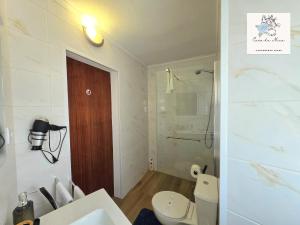 a white bathroom with a toilet and a shower at Casa da Mica in Faja Grande +15 photos