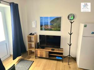 a living room with a flat screen tv on a stand at Casa da Mica in Faja Grande