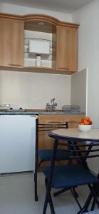 a kitchen with a table and a bowl of oranges at Apartman Vuk in Budva