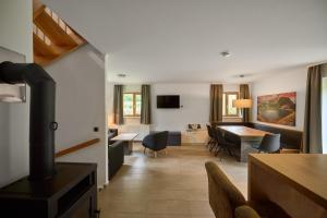 a living room with a kitchen and a dining room at Chalet Resort Montafon I - Chalets & Chalet-Apartments in Sankt Gallenkirch