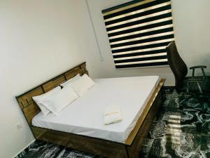 a bedroom with a bed with a book on it at Lazeto Hotel & Resort in Zokoja