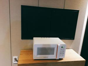 a microwave sitting on top of a wooden table at IDEA Hotel in Busan